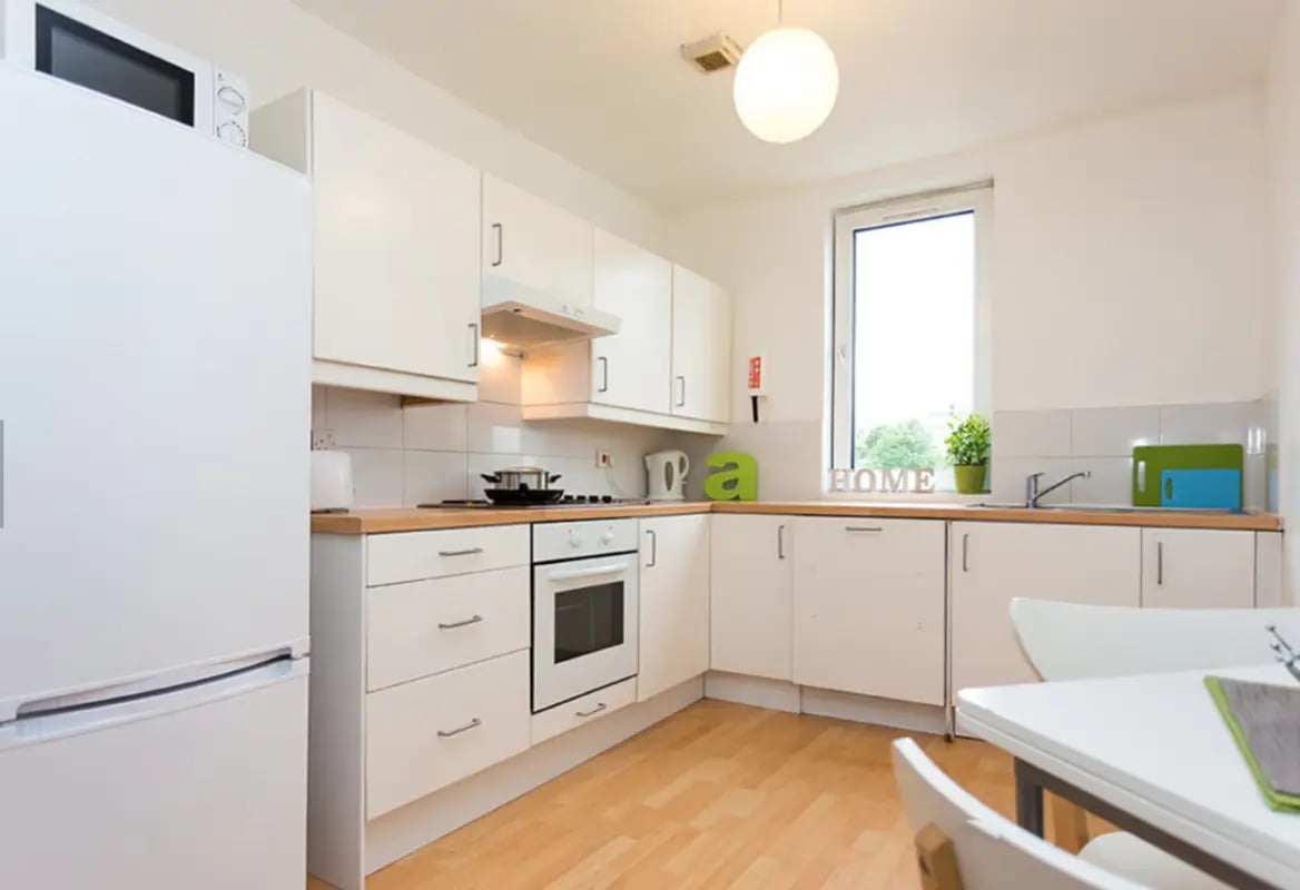 White cabinets microwave oven and fridge kitchen at King Street 207 in Aberdeen Student Accommodation